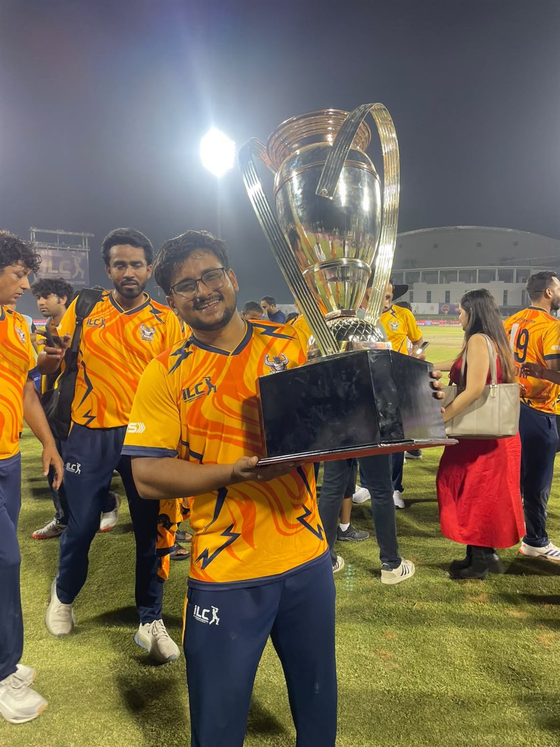 Dr. Sandeep lifting a trophy at a cricket league night